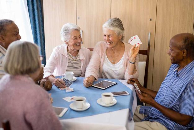 senior people enjoying tea while playing cards senior people enjoying tea while playing cards