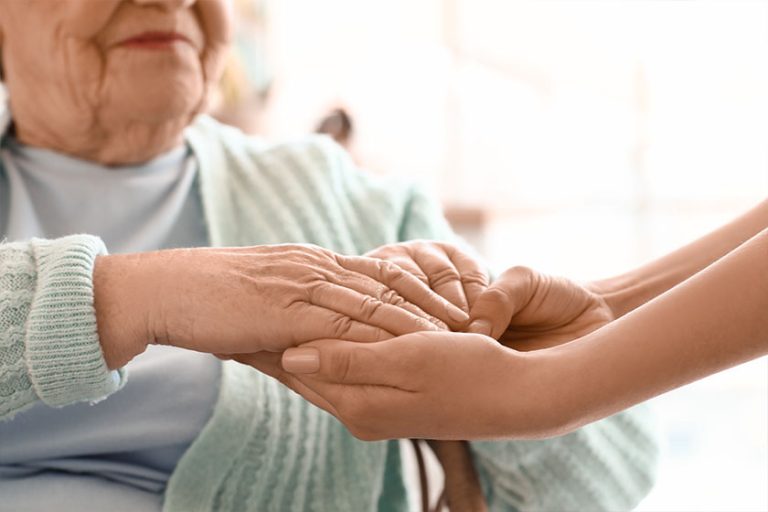 senior woman her granddaughter holding hands home closeup