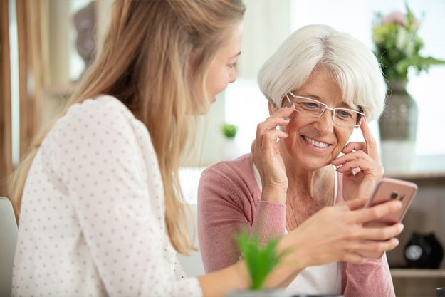 smiling mother daughter using cell phone smiling mother daughter using cell phone