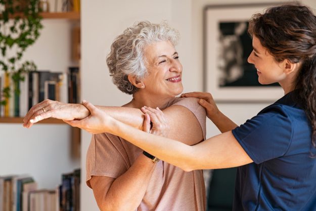Happy,Senior,Woman,Doing,Exercise,At,Home,With,Physiotherapist.,Old Happy,Senior,Woman,Doing,Exercise,At,Home,With,Physiotherapist.,Old