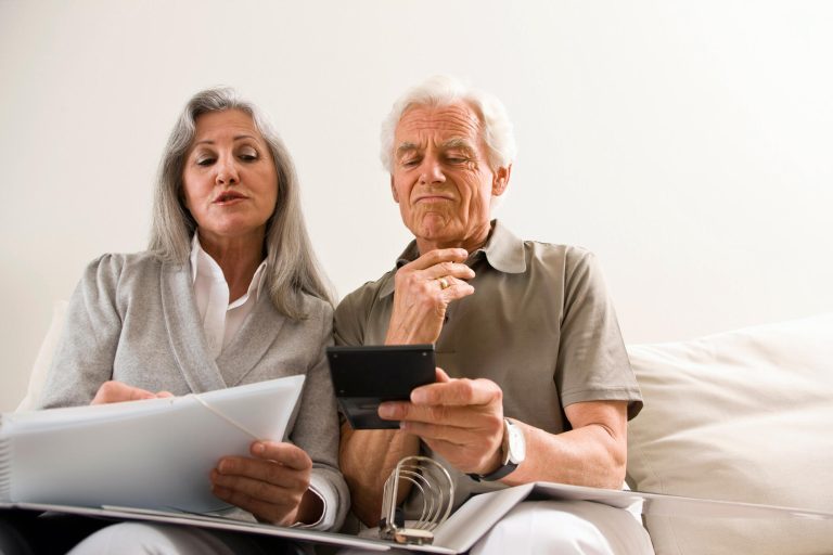 A,Senior,Couple,Calculating,Finances,Sitting,On,Sofa.