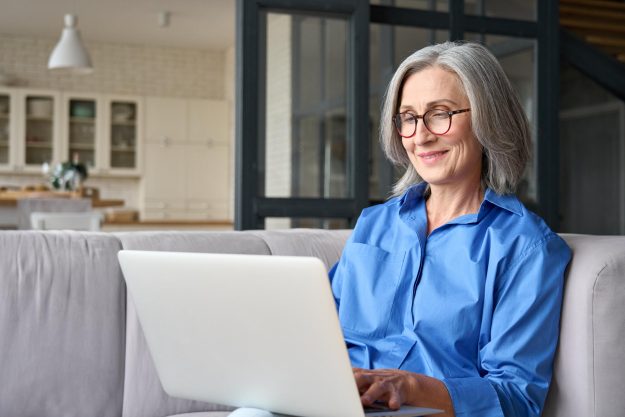 Older,Smiling,60s,Woman,Sitting,At,Home,On,Sofa,,Holding Older,Smiling,60s,Woman,Sitting,At,Home,On,Sofa,,Holding