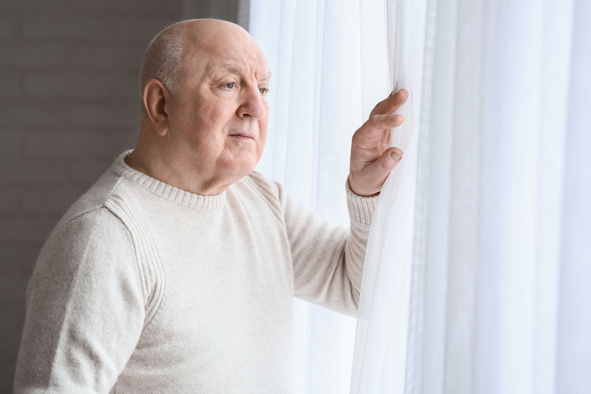 Elderly man suffering from mental disability near window at home