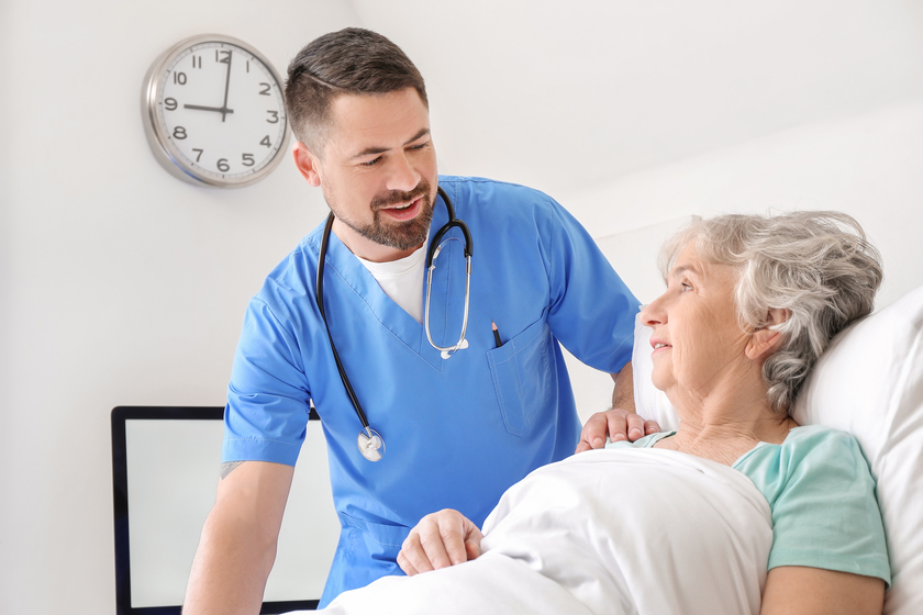 Male doctor working with elderly patient in hospital room Male doctor working with elderly patient in hospital room