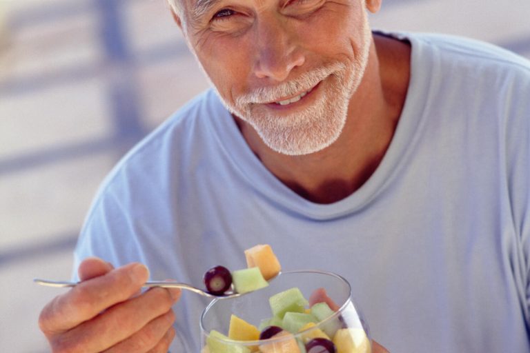 Portrait,Of,Mature,Man,Eating,Fruit,Cocktail