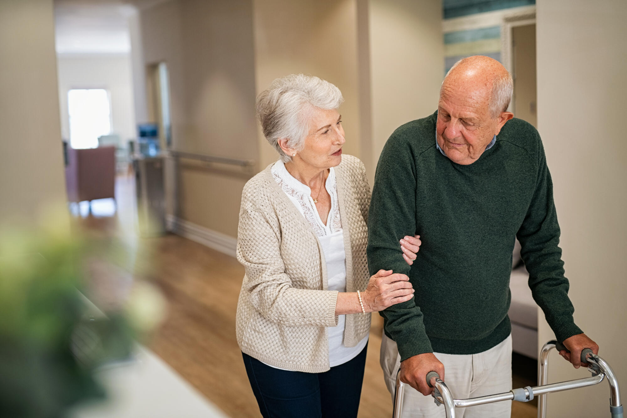 Elderly,Woman,Help,Her,Husband,Walking,Using,Walker,In,Nursing