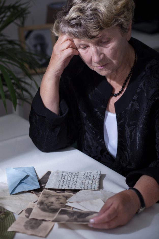 Elderly,Woman,In,Mourning,Watching,Old,Photos