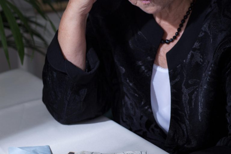 Elderly,Woman,In,Mourning,Watching,Old,Photos