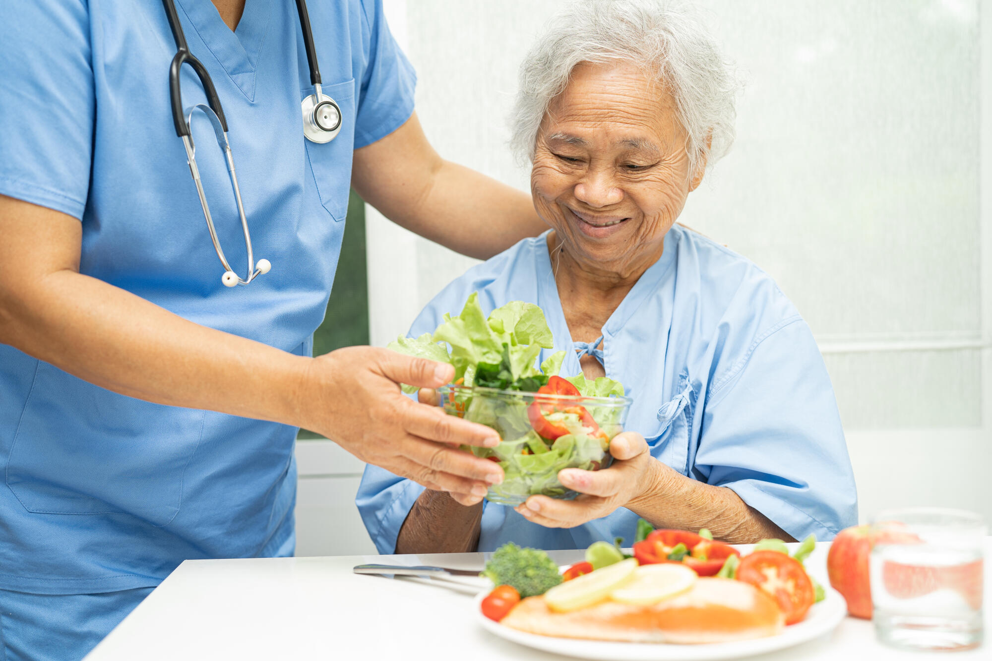 Asian elderly woman patient eating salmon steak breakfast with v
