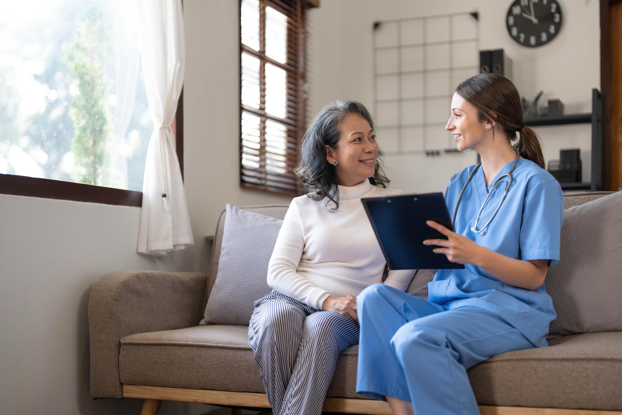 Asian nurse showing health checkup report to grandmather and giv