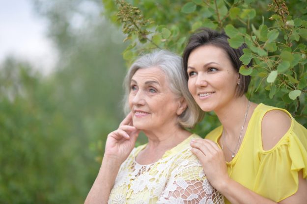 Beautiful elderly woman with her daughter walking in park Beautiful elderly woman with her daughter walking in park
