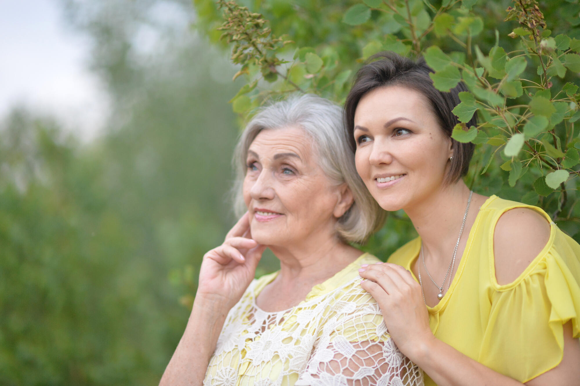 Beautiful elderly woman with her daughter walking in park Beautiful elderly woman with her daughter walking in park