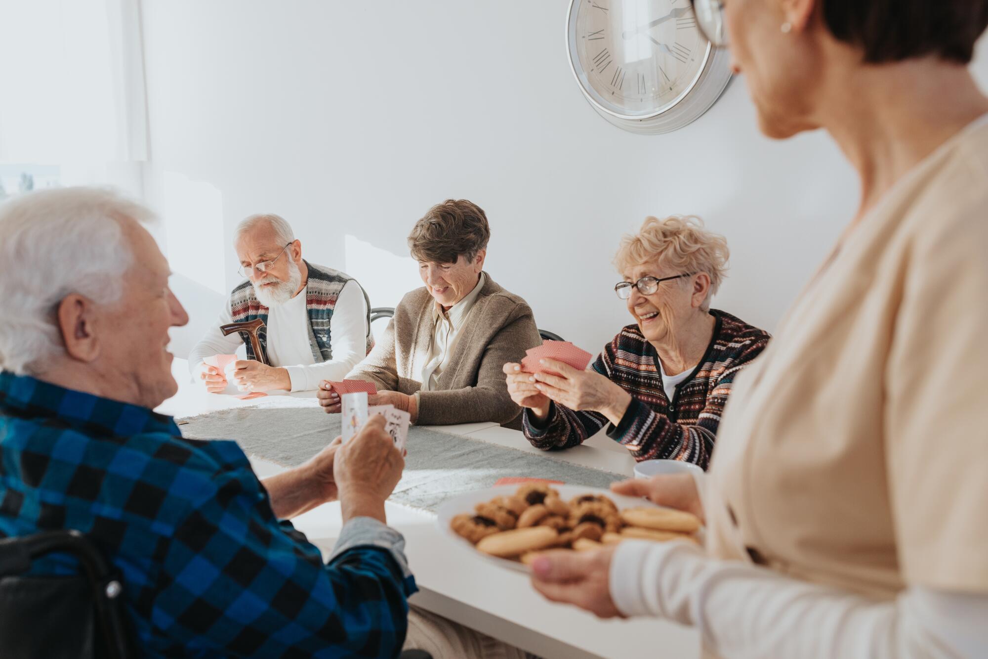 Group,Of,Senior,People,Playing,Cards,Togetehr,In,Common,Room