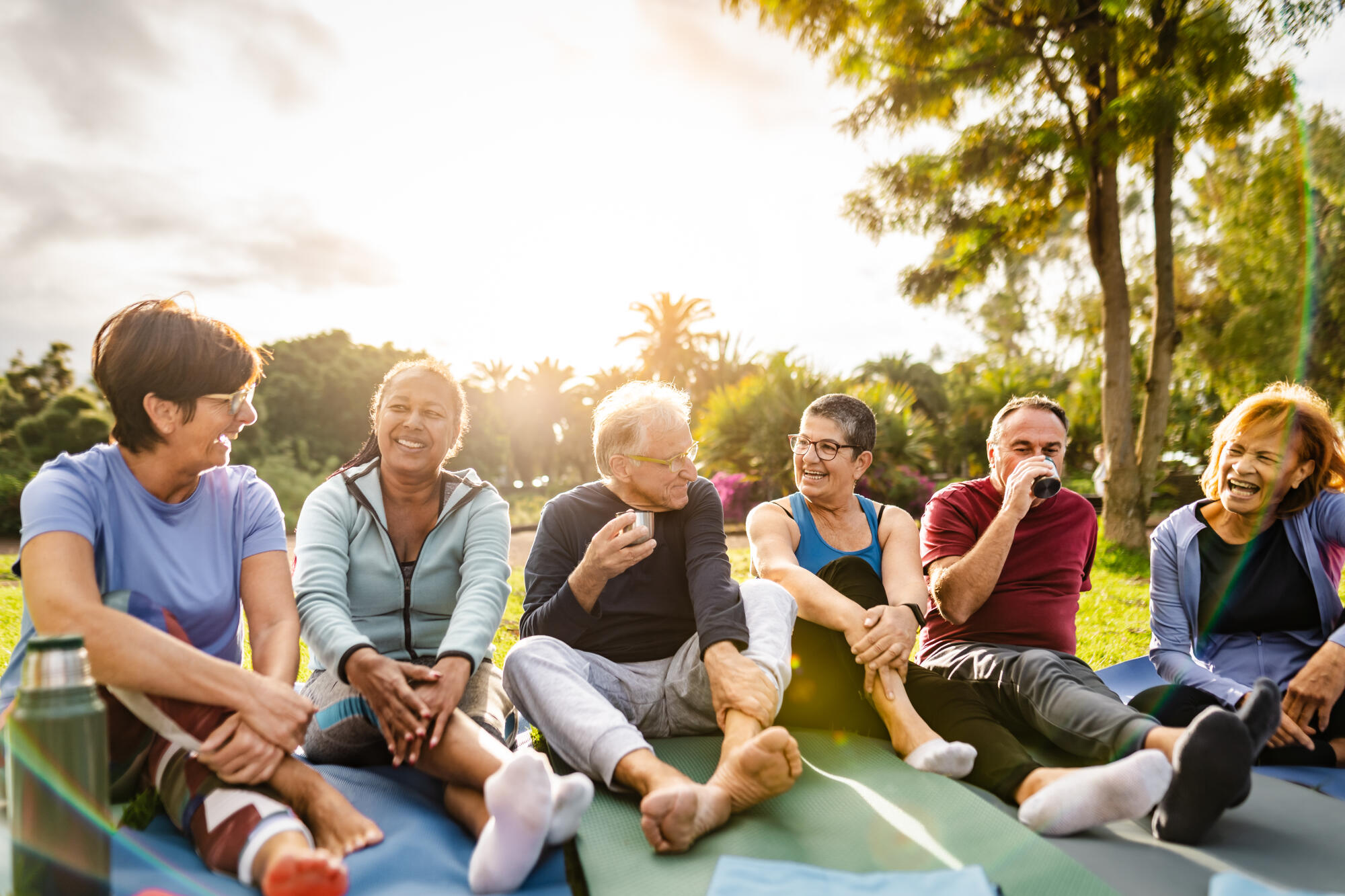Happy multiracial senior friends drinking a tea after workout ac Happy multiracial senior friends drinking a tea after workout ac