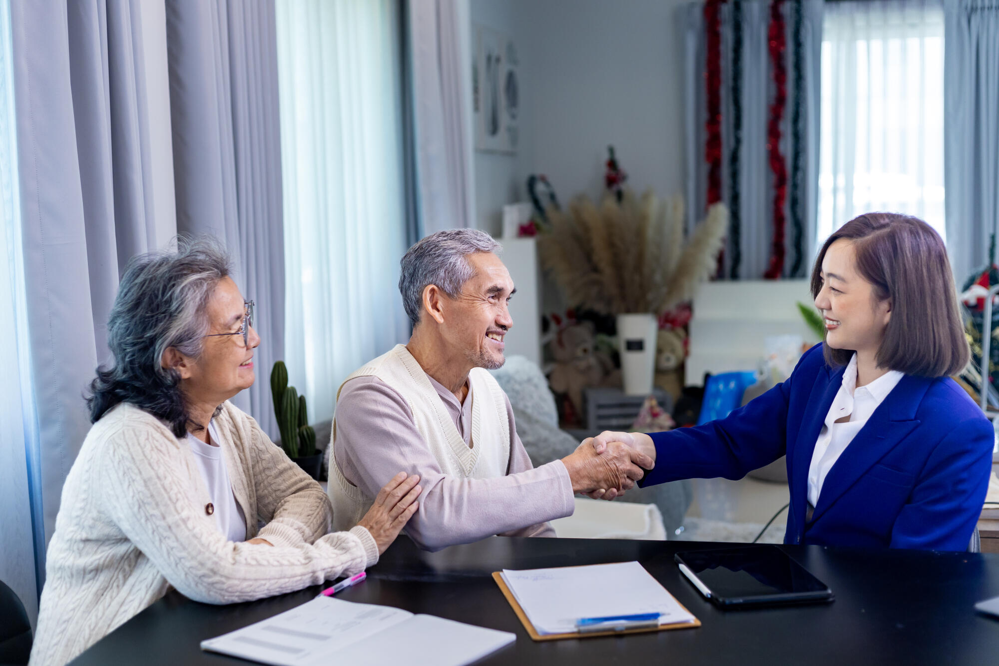 Asian senior couple handshaking the lawyer after finish financia Asian senior couple handshaking the lawyer after finish financia