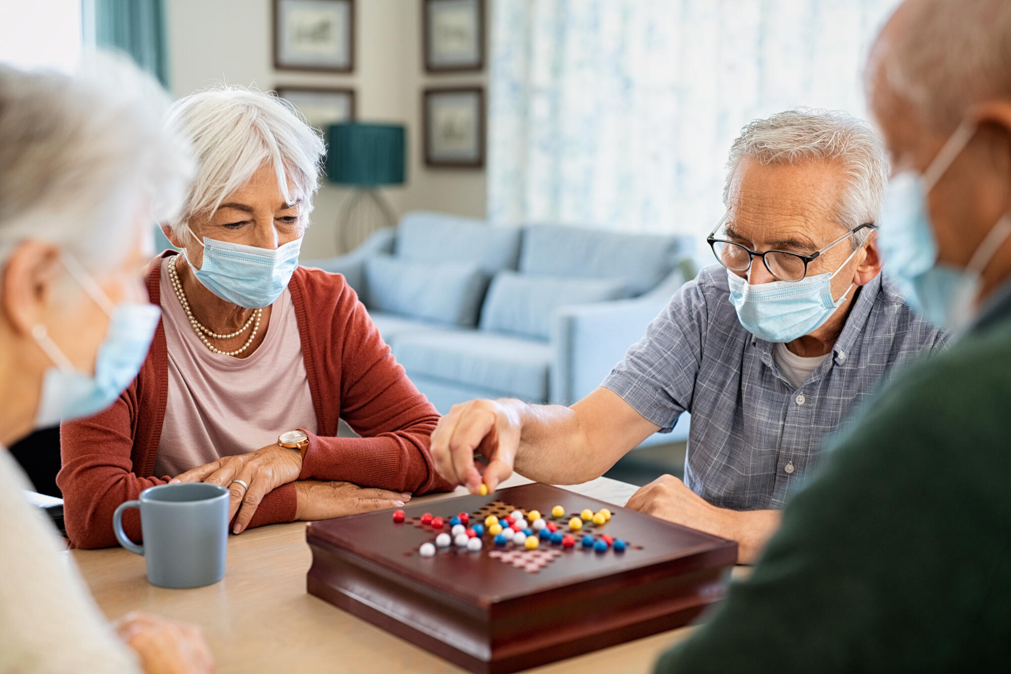 Group,Of,Seniors,Wearing,Protective,Face,Mask,Playing,Chinese,Checkers