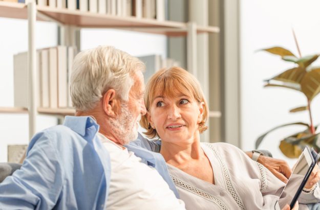 Senior couple in living room, Elderly man and a woman using tabl Senior couple in living room, Elderly man and a woman using tabl