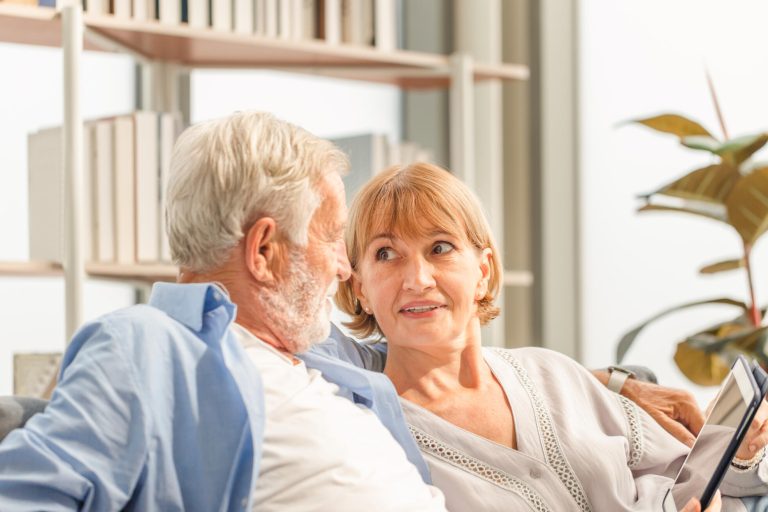 Senior couple in living room, Elderly man and a woman using tabl