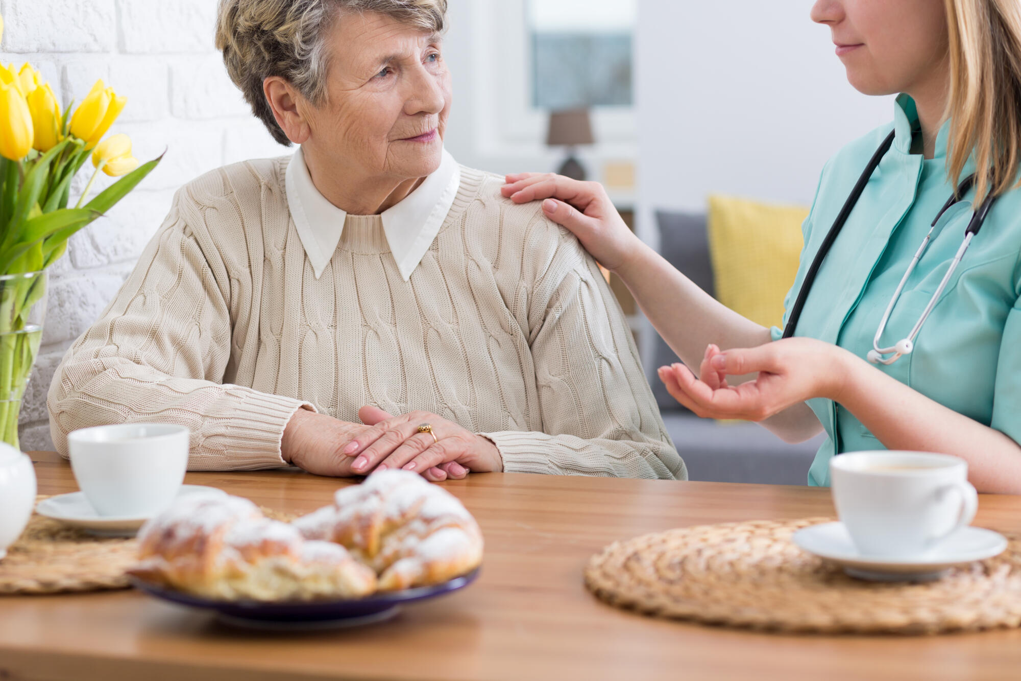 Senior,Lady,Sitting,At,A,Table,With,Her,Home,Nurse,