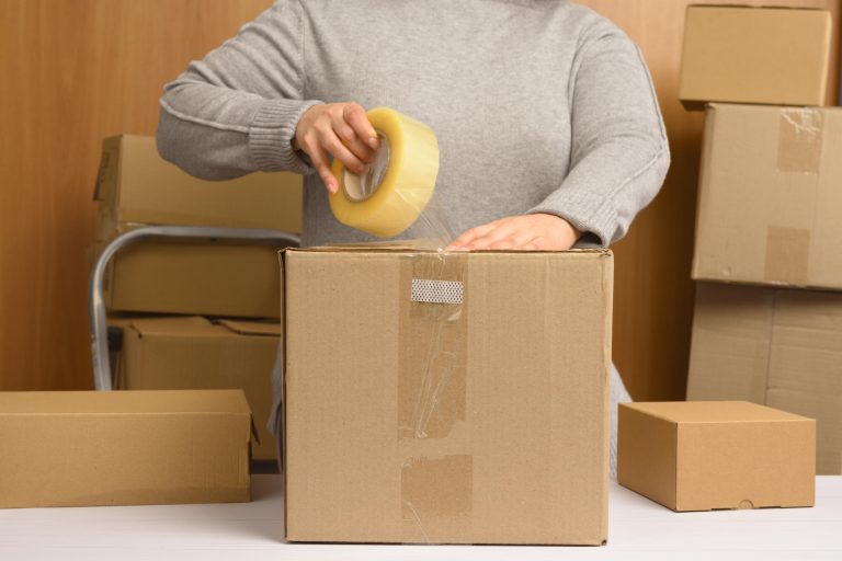 Woman,In,A,Gray,Sweater,Holds,A,Roll,Of,Duct