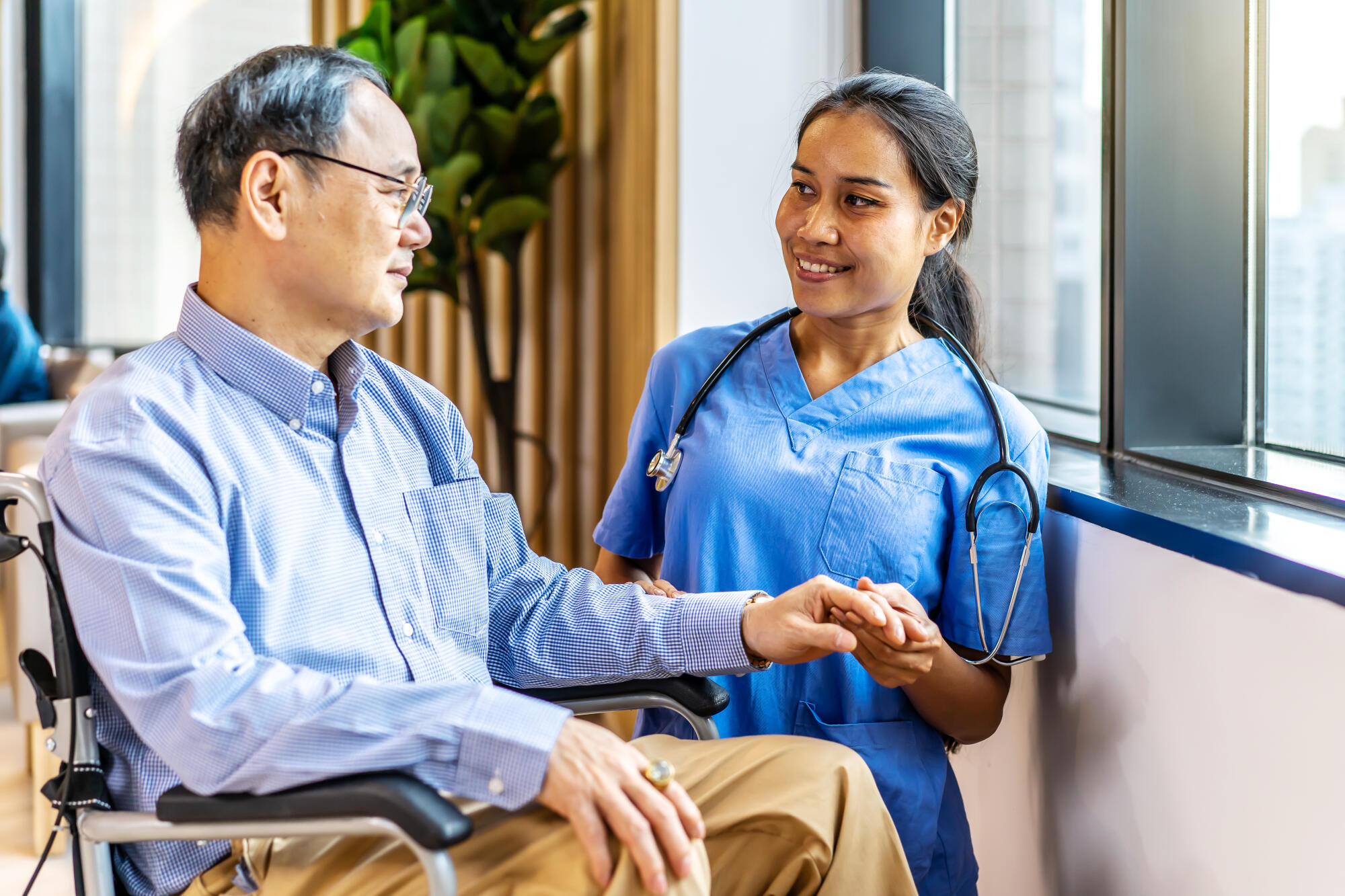 Asian female doctor or nurse treats elderly patient suffering fr