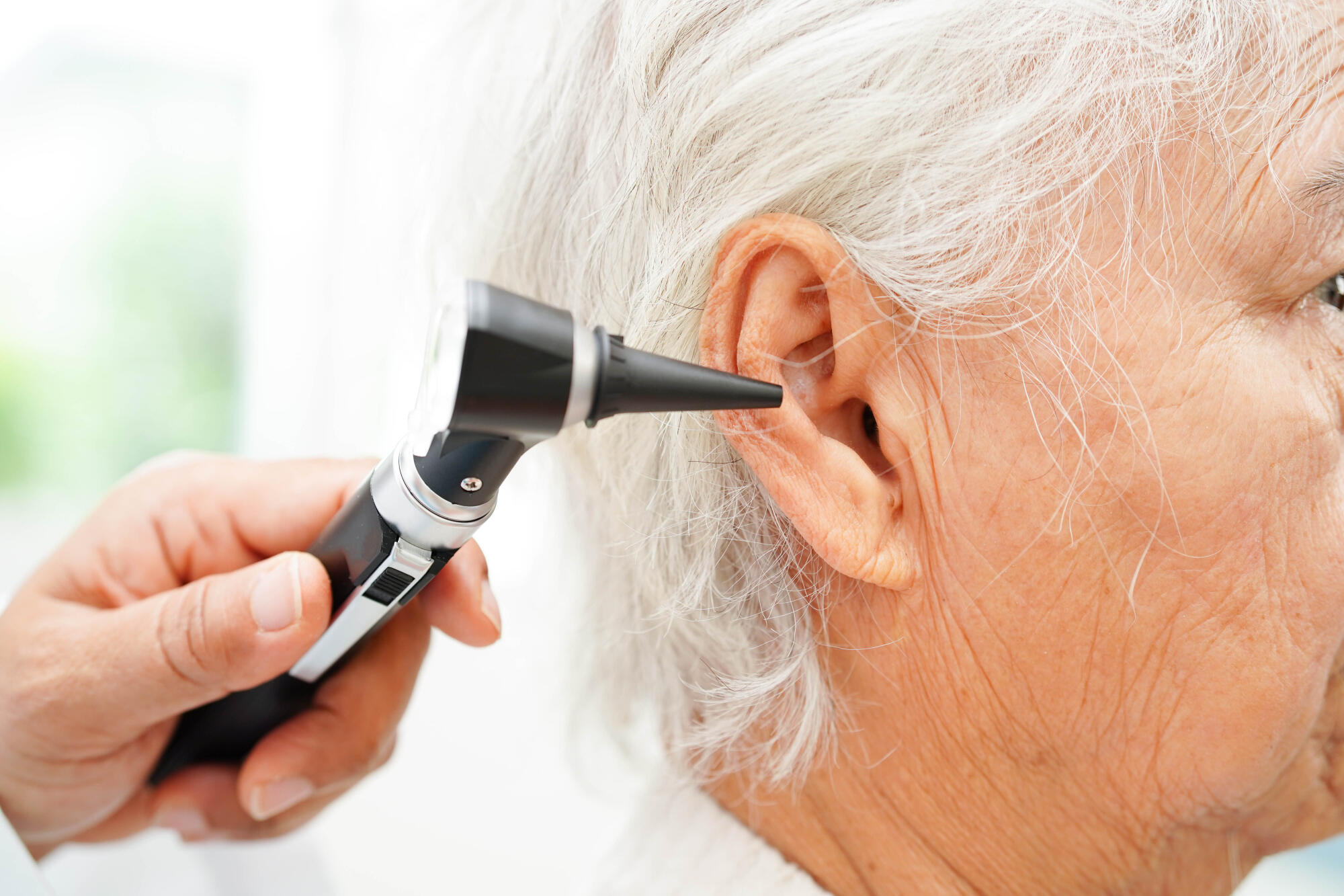 Otolaryngologist or ENT physician doctor examining senior patien