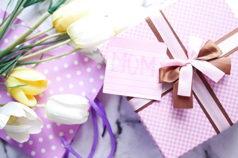 Top view of mother day gift and flower on table.