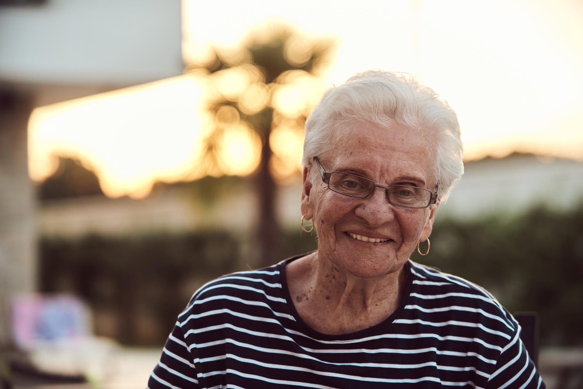 Unfiltered portrait, a real elderly woman sits gracefully in a chair, showcasing the authenticity of aging with wrinkles and a natural face