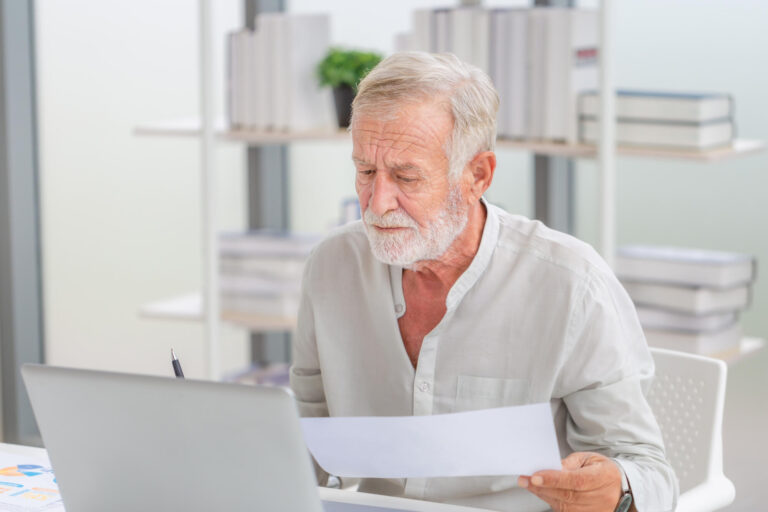 Worried senior man checking their bills, retired elderly old fam