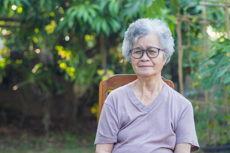 An elderly woman with short gray hair smiling and looking at the