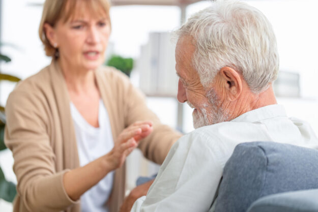 Senior couple in living room, Elderly man consulting senior woma Senior couple in living room, Elderly man consulting senior woma