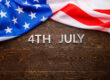 the words 4th july and crumpled usa flag on flat textured wooden surface background