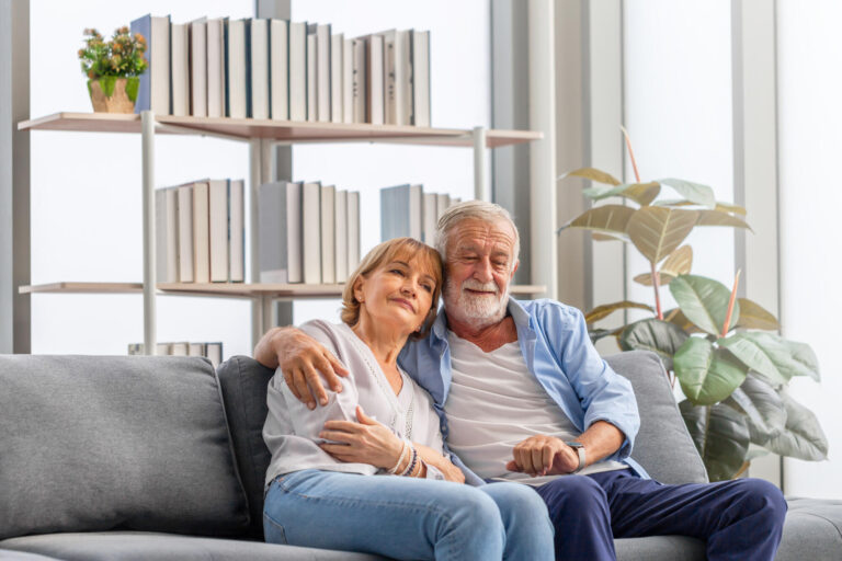 Elderly woman and a man relaxing on cozy sofa at home, Happy sen