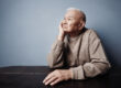 Pensive and thoughtful senior man sitting at the table
