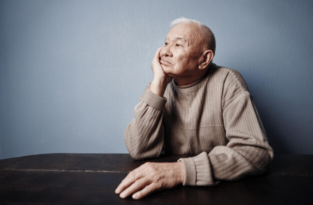 Pensive and thoughtful senior man sitting at the table Pensive and thoughtful senior man sitting at the table