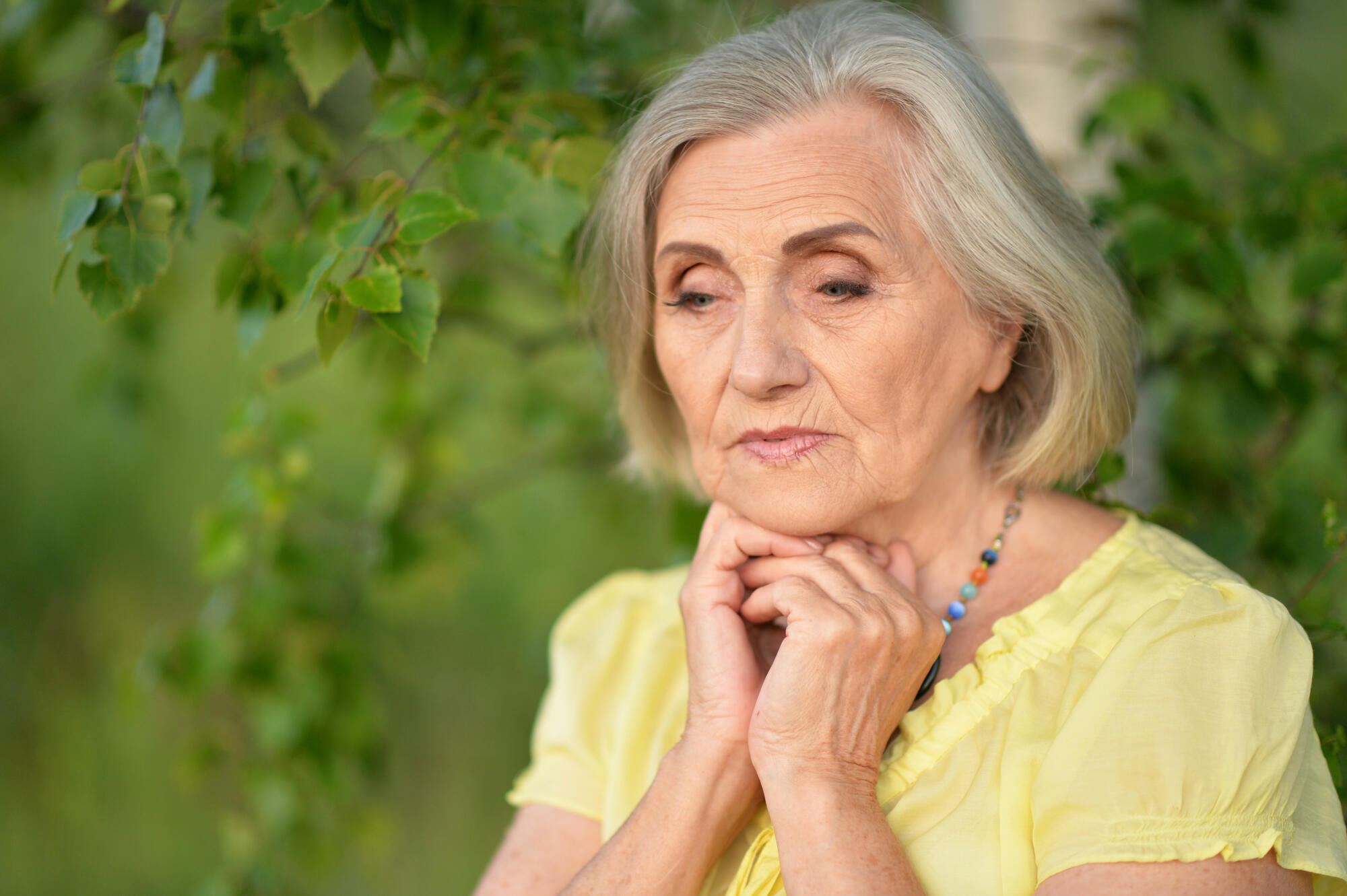 Portait of beautiful sad senior woman in park Portait of beautiful sad senior woman in park