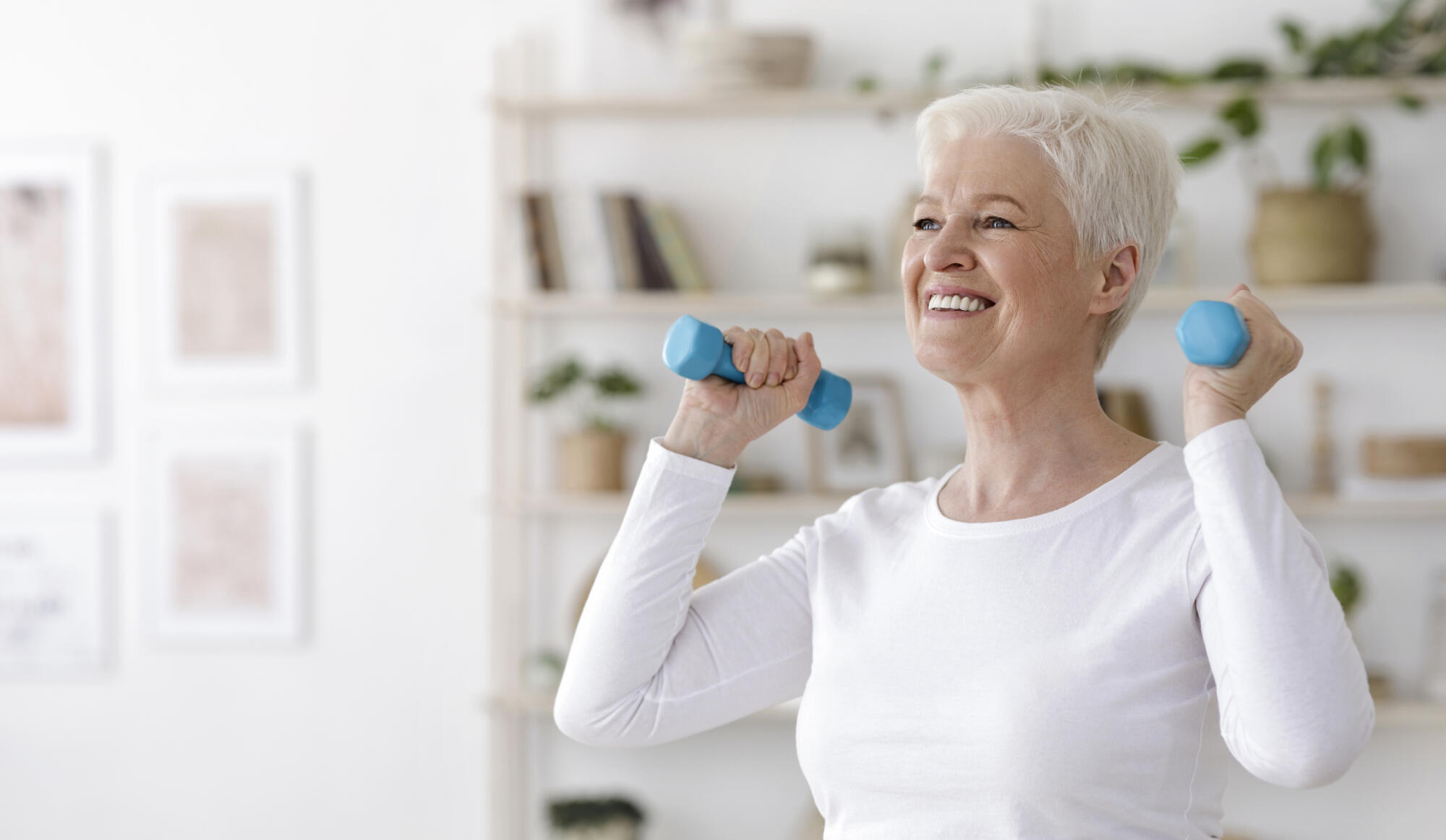 Healthy Lifestyle. Smiling Senior Lady Exercising With Dumbbells At Home