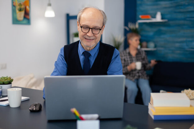Old woman relaxing on couch holding a cup of coffee