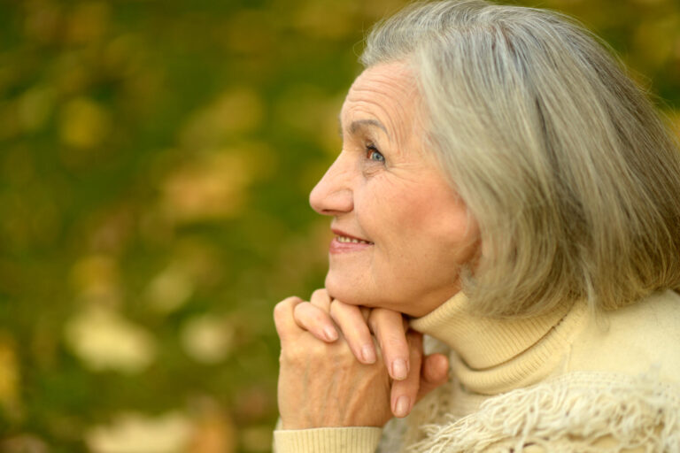 Portrait of senior woman walking in autumn park