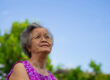Portrait of an elderly Asian woman wearing glasses and looking u