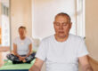 Close up of a senior man deeply focused on meditation and relaxation during a yoga practice.