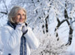 Beautiful elderly woman posing in a snowy winter park