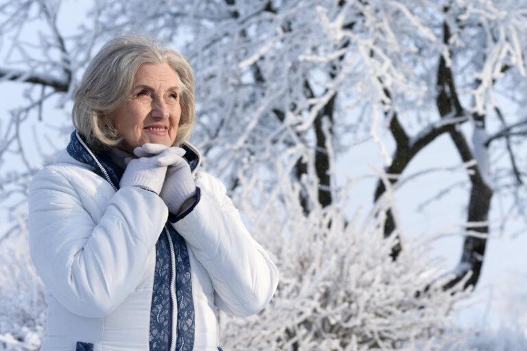 Beautiful elderly woman posing in a snowy winter park