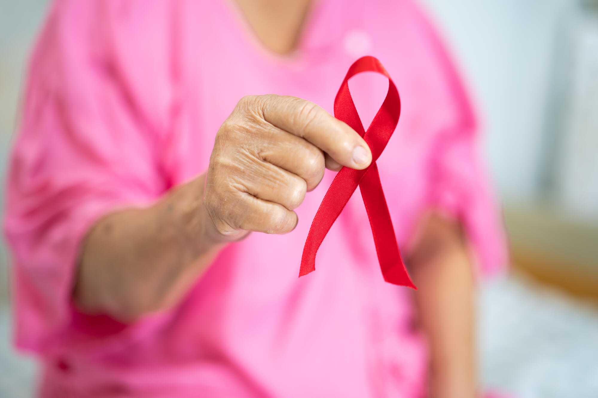 Breast cancer, pink ribbon at Asian senior lady patient for supp