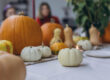 Children and adults painting pumpkins for Halloween, enjoying a fun and creative activity together.