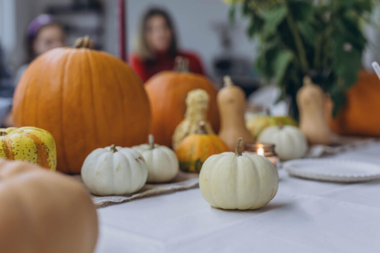 Children and adults painting pumpkins for Halloween, enjoying a fun and creative activity together.