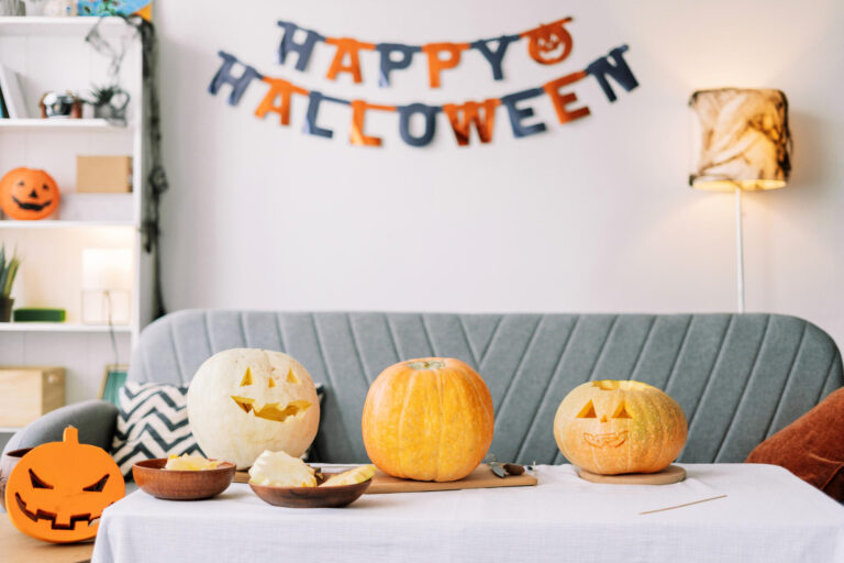 Pumpkin carving and festive garland on the wall preparing Halloween decorations at home