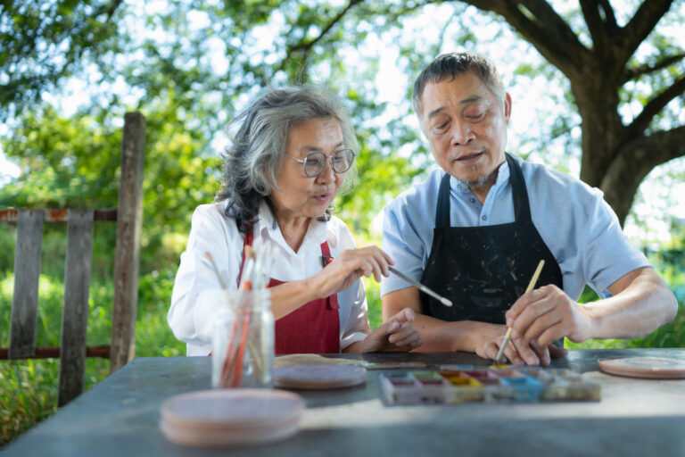 In the pottery workshop, an Asian retired couple is engaged in p